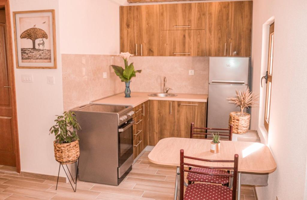 a kitchen with a sink and a table and a refrigerator at Apartmani Dumezic in Bar