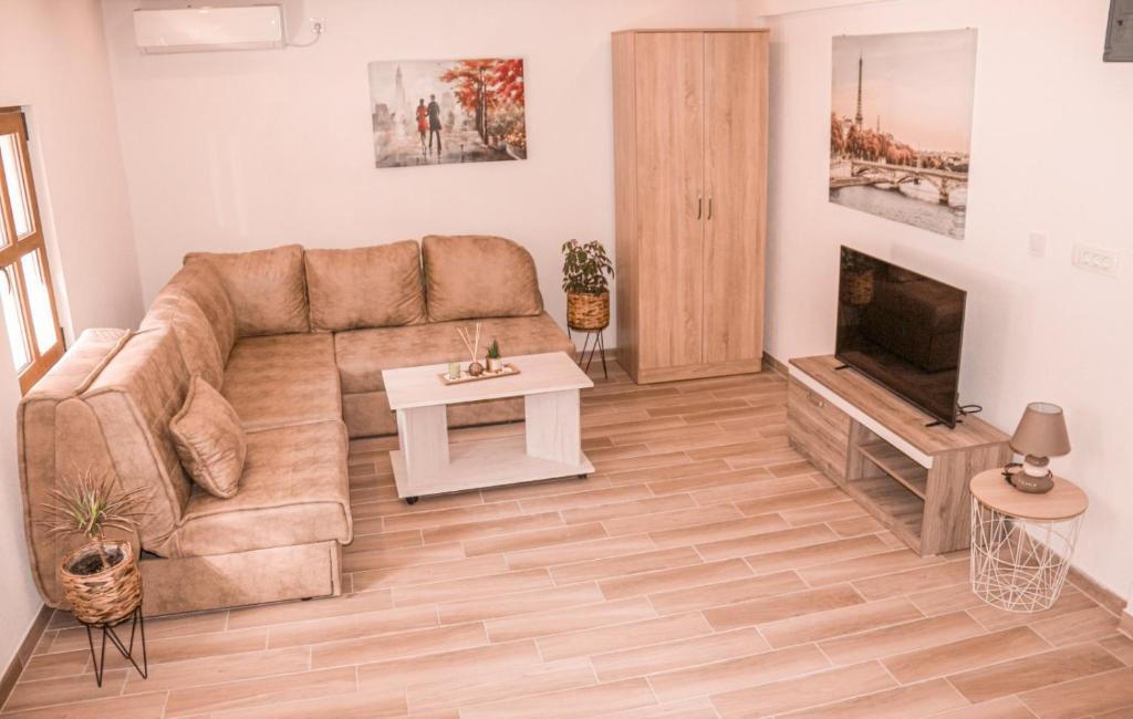 a living room with a couch and a tv at Apartmani Dumezic in Bar