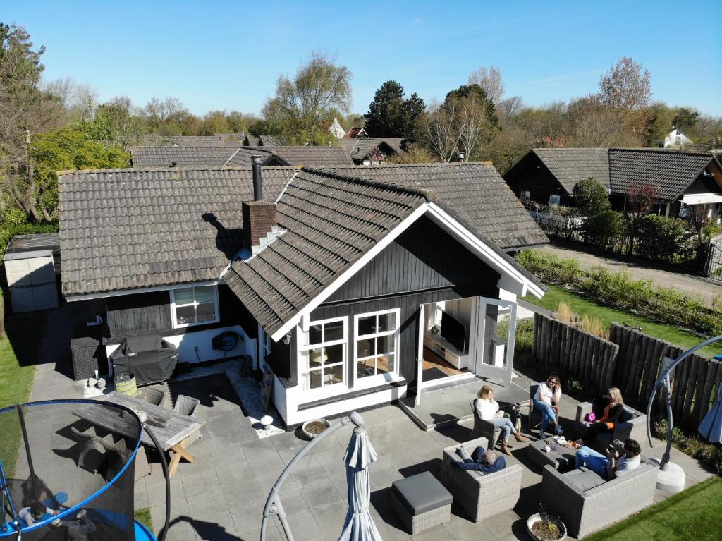 una vista aérea de una casa con gente sentada en un patio en Heerlijke bungalow op 350 meter vanaf het strand!, en Ouddorp
