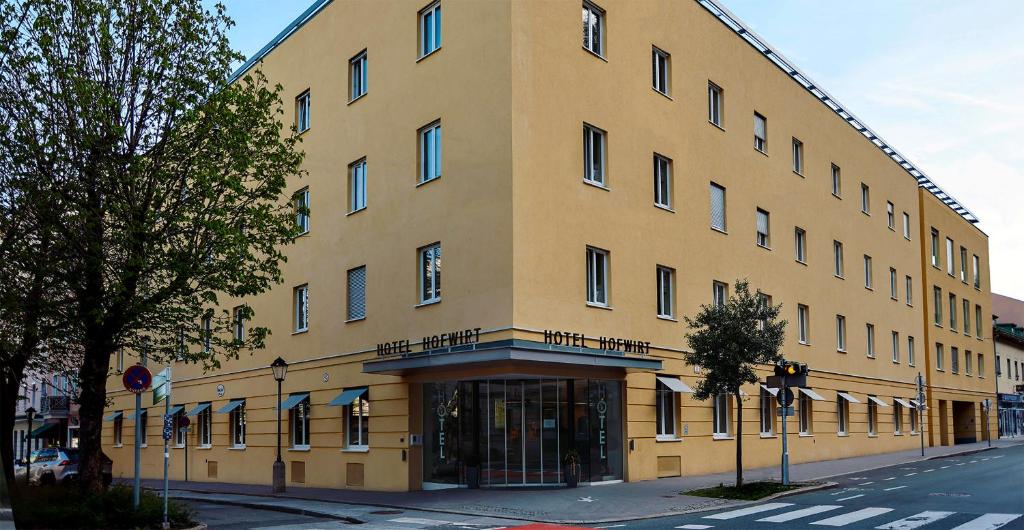 ein großes gelbes Gebäude an der Ecke einer Straße in der Unterkunft Altstadt Hotel Hofwirt Salzburg in Salzburg