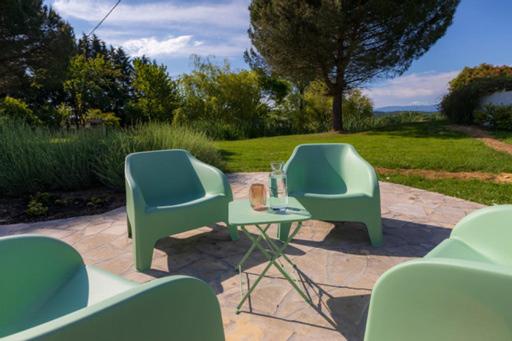 two green chairs and a table with a glass at Au Temps Suspendu in Saint-Martin-dʼOydes