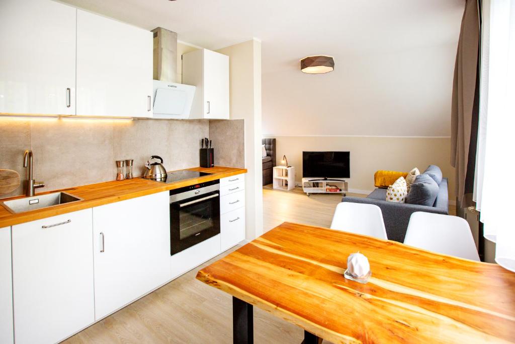 kuchnia i salon z drewnianym stołem w obiekcie Modernes Studio in Stadtnähe w mieście Würzburg