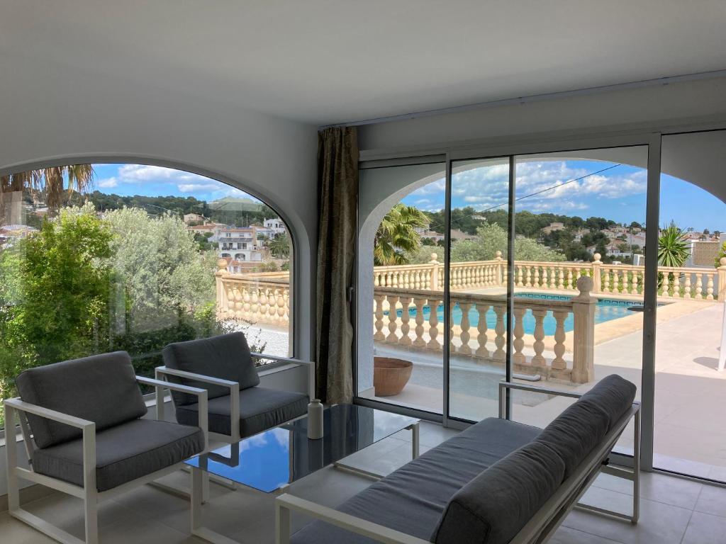 a living room with two chairs and a view of a pool at Villa mit privatem Pool 10 Minuten vom Strand mit kostenlosen WiFi in Benissa