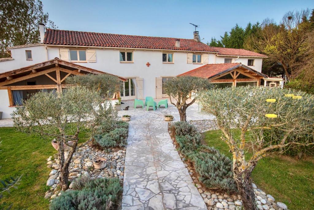 a house with a garden in front of it at Au Temps Suspendu in Saint-Martin-dʼOydes