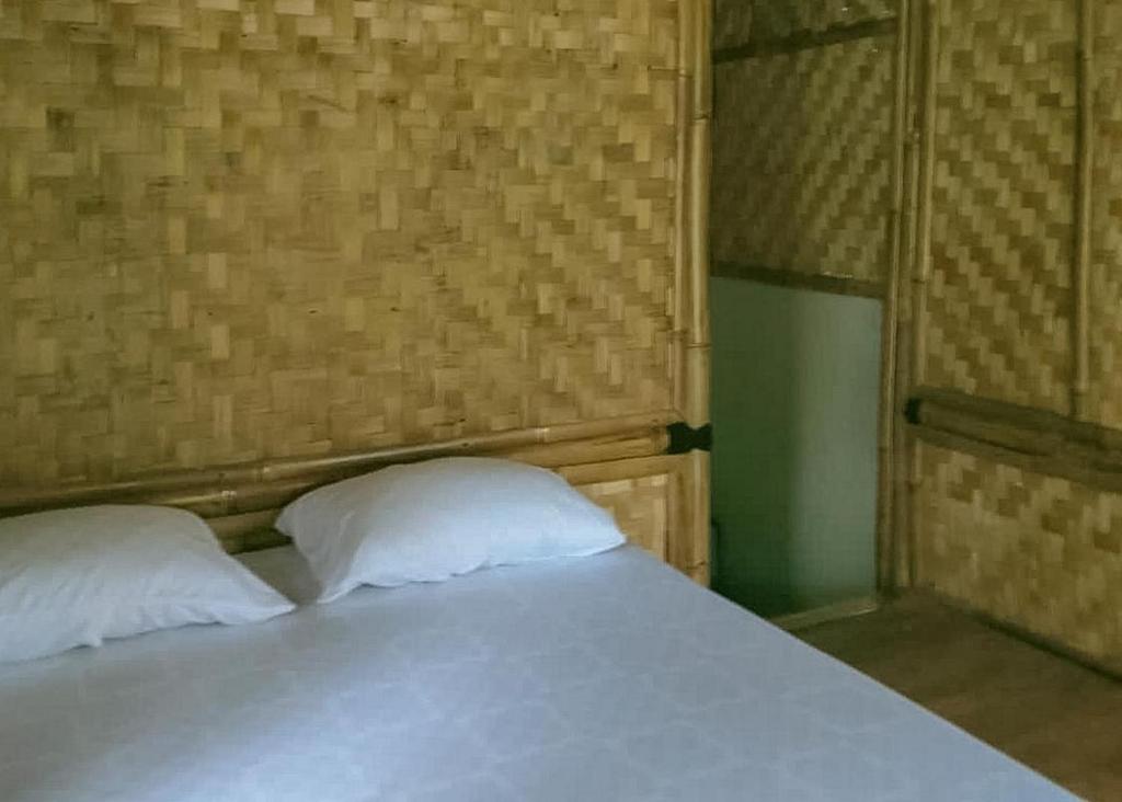 a bed with two white pillows in a room at Lembah Cawene Hills Syariah RedPartner in Gunungpicung