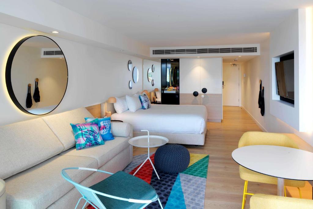 um quarto de hotel com uma cama e um sofá em QT Bondi em Sydney