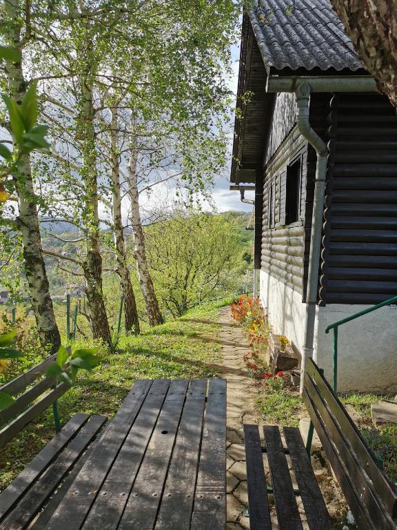 a wooden path next to a building with a bench at KOZJANSKA KOČA in Podčetrtek