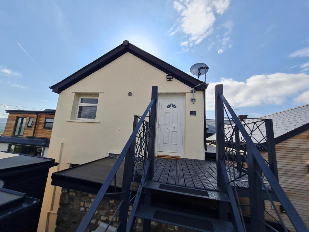 a house with a white door on a deck at Perfect Location 2 BR serviced apartment Nr Bike Park Wales & Brecon Beacons in Merthyr Tydfil