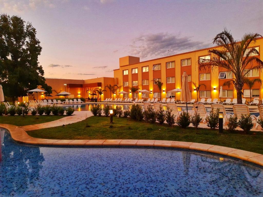 um hotel com piscina em frente a um edifício em Days Inn Zarate em Zárate