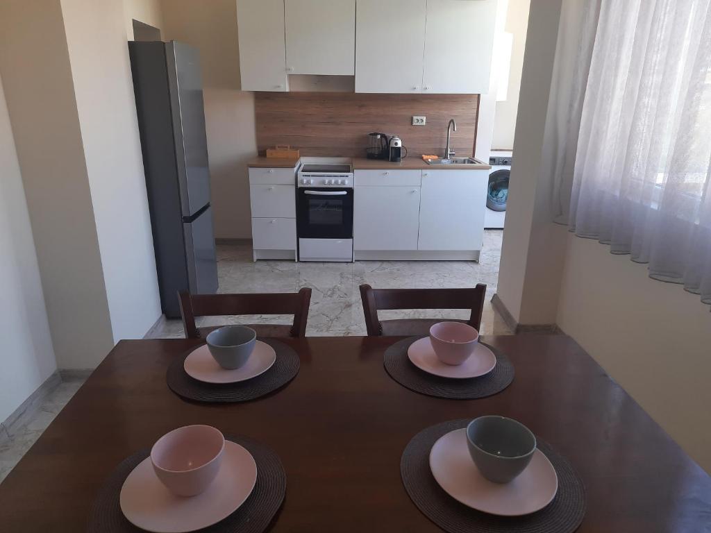 a table with three cups and plates on it in a kitchen at Sandanski city center apartment in Sandanski