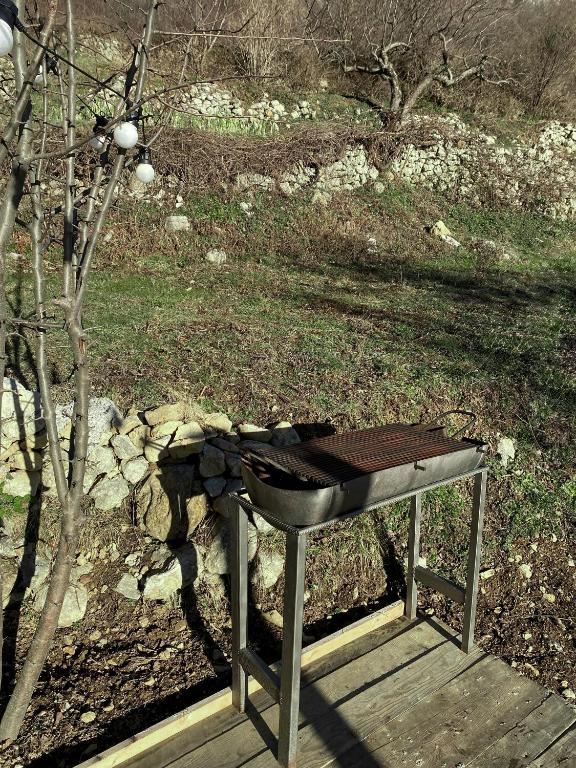 a grill sitting on a wooden platform next to a tree at Horizon Lodge Medurec in Ulcinj