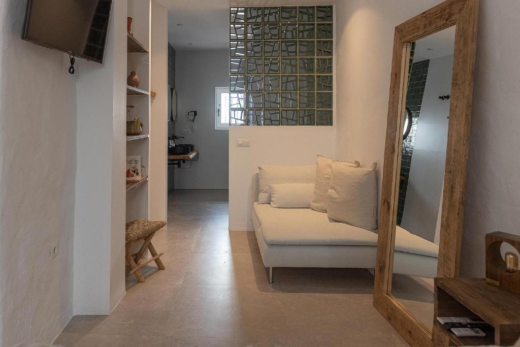 salon z białą kanapą i lustrem w obiekcie Hospedería Boutique by La Judería De Vejer- ADULTS ONLY w mieście Vejer de la Frontera