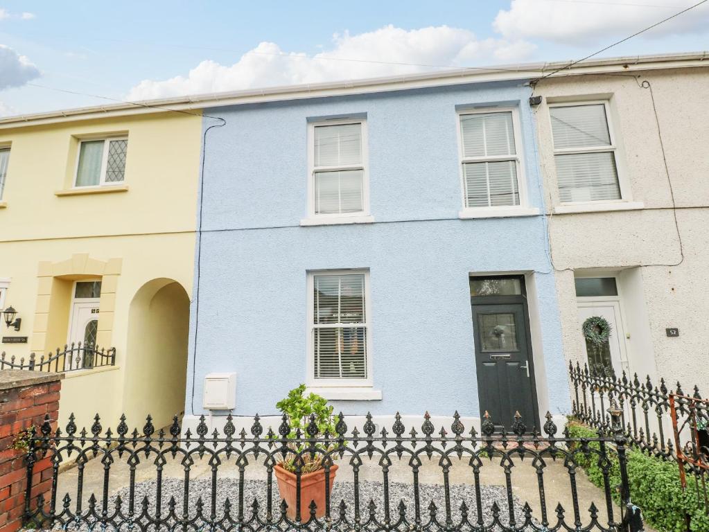 a blue house with a fence in front of it at 54 Pencoed Road in Burry Port