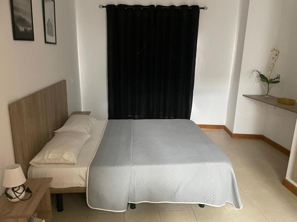 アレシーフェにあるApartamentos Carlota IIのベッドルーム1室(ベッド1台、黒いカーテン付)