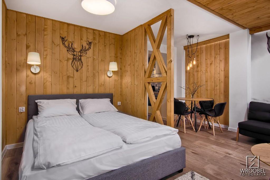 a bed in a room with a wooden wall at Zakopiańska Gawra in Zakopane