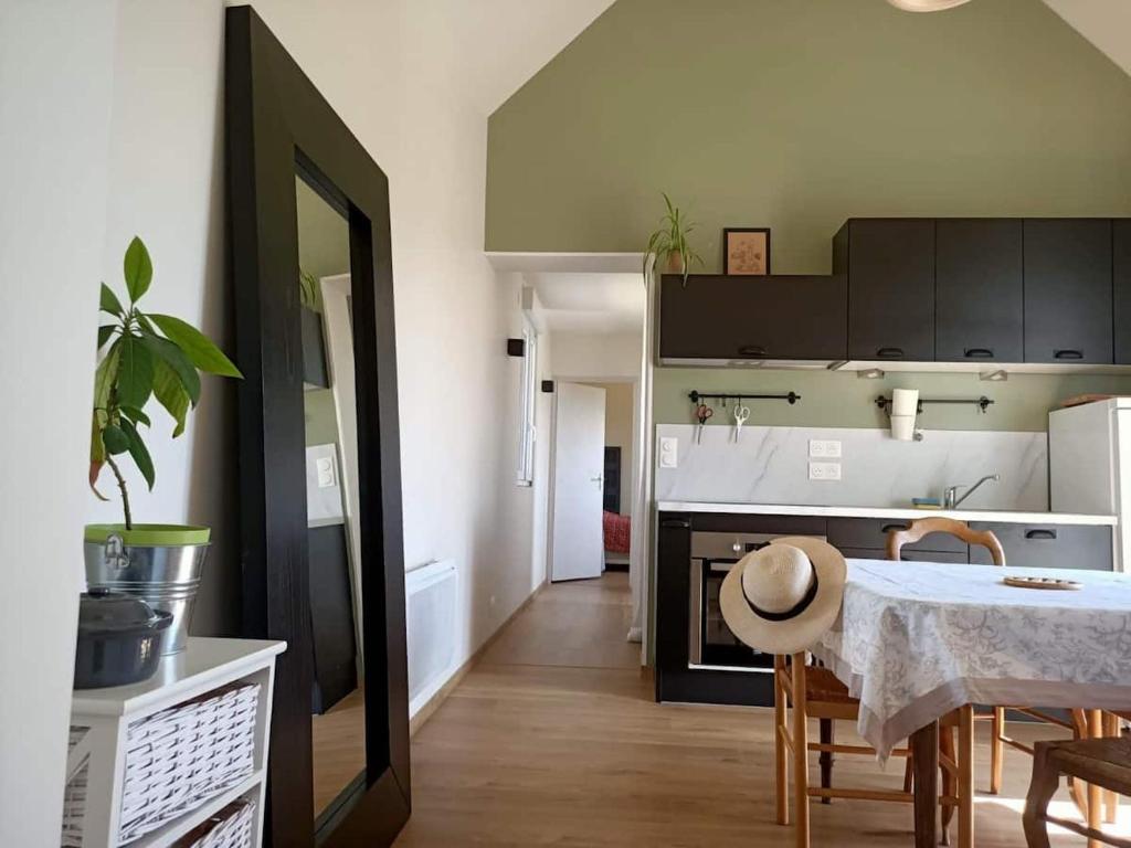 a kitchen and dining room with a table and chairs at La cabane de la mare - Meublé de tourisme 3 étoiles in Précy