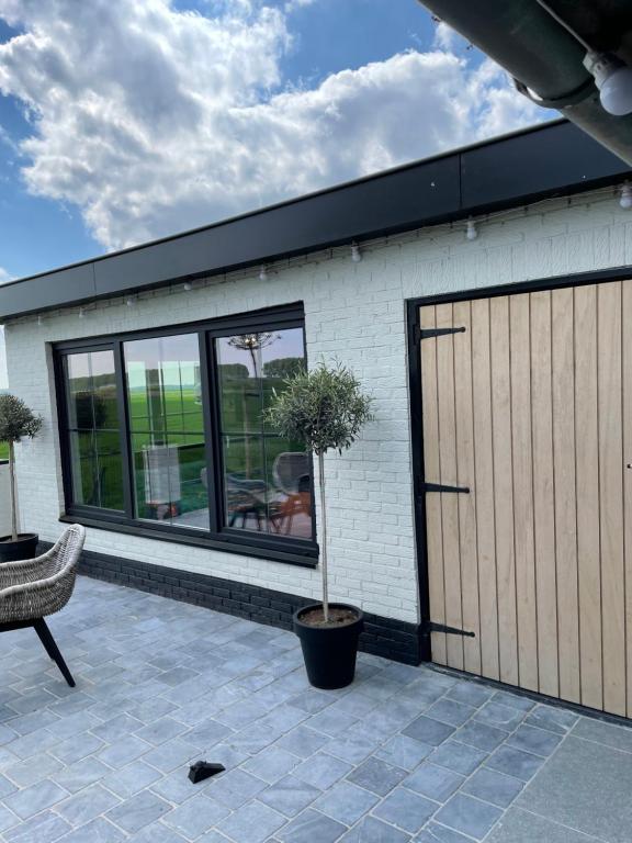 un edificio con una puerta de garaje y una maceta en Tiny House en Westdorpe