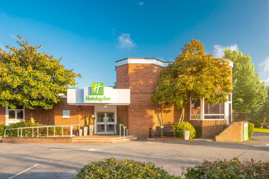 a brick building with a sign for a pharmacy at Holiday Inn Basingstoke, an IHG Hotel in Basingstoke
