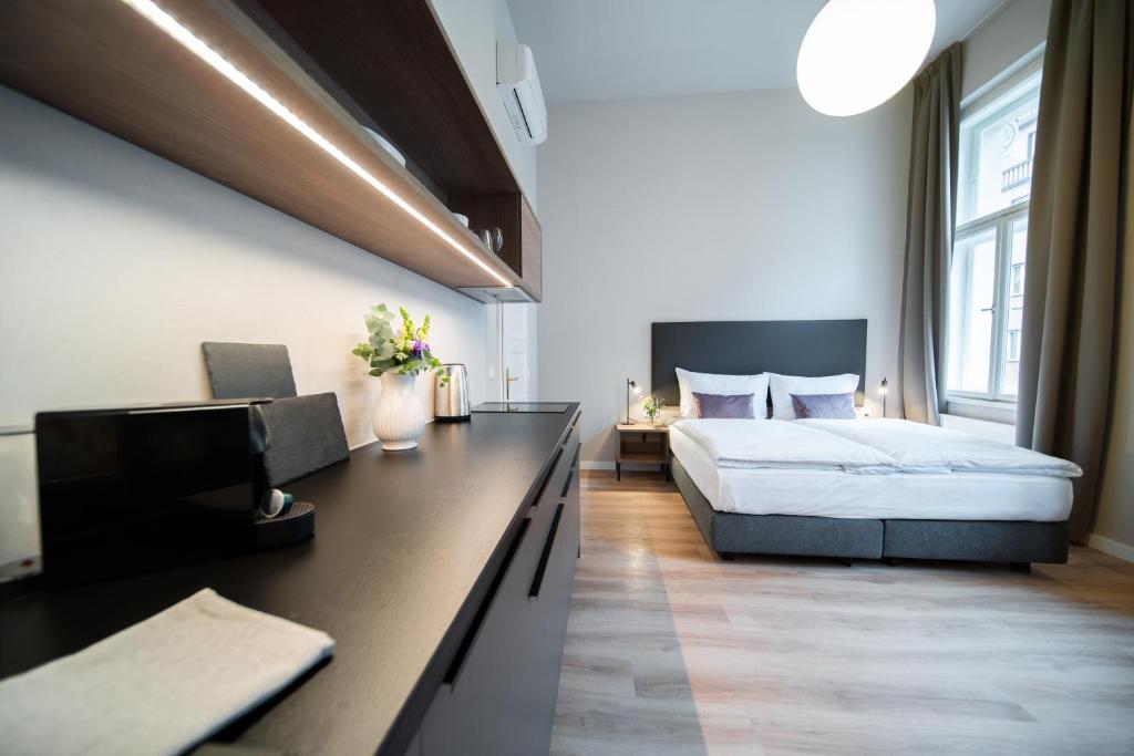 um quarto com uma cama e uma secretária com uma televisão em Karl BY ZEITRAUM em Praga