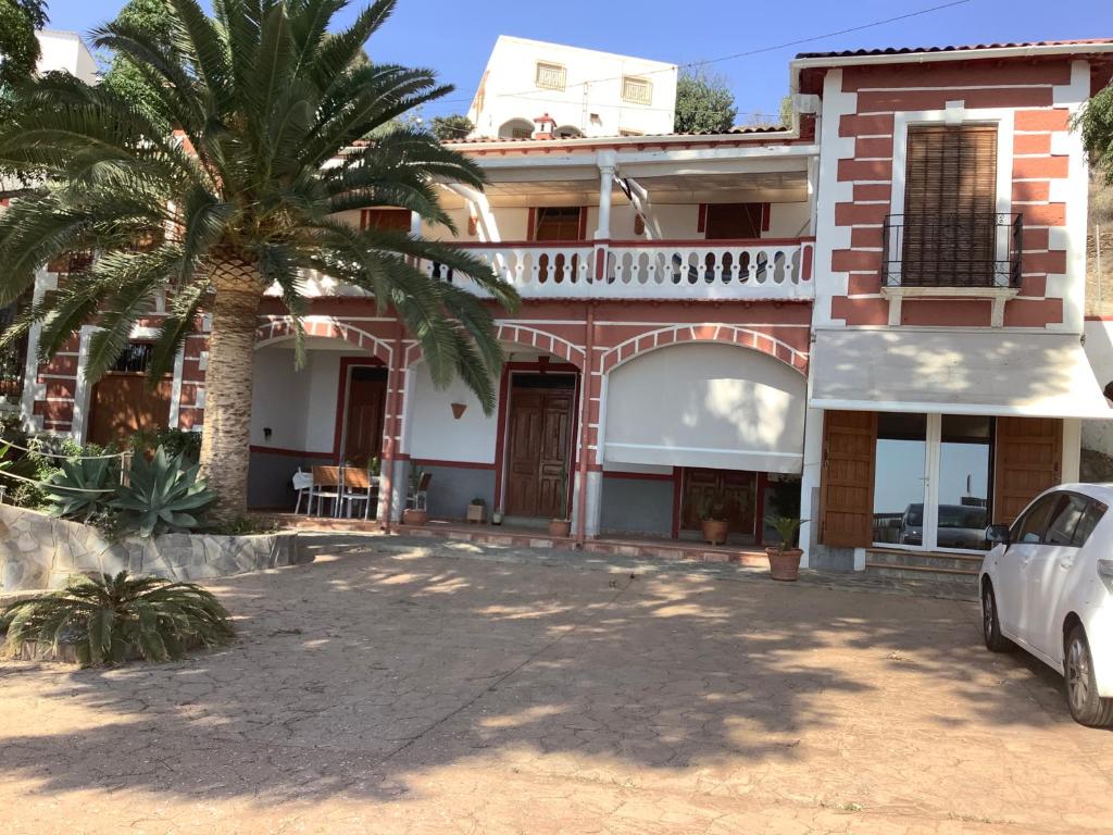 ein Haus mit einer Palme davor in der Unterkunft Cortijo de la Fuente in Albuñol