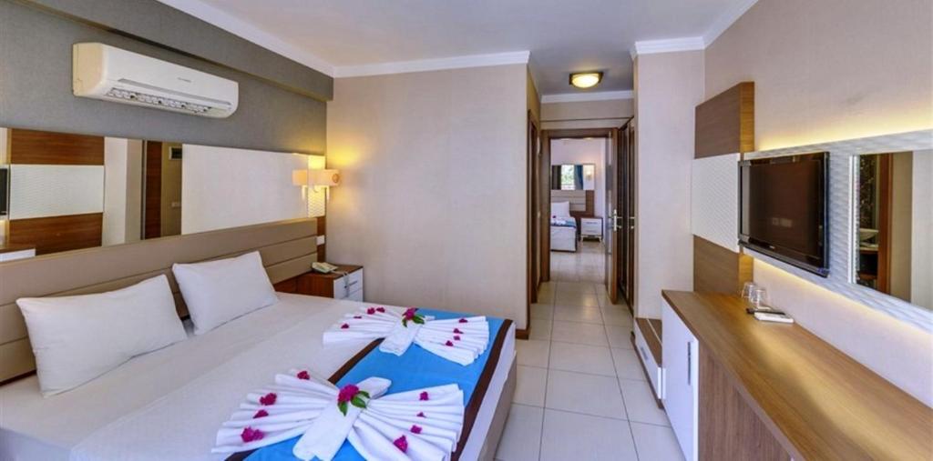 オルデニズにあるMarcan Resort Hotelのベッドルーム1室(花の飾られたベッド1台付)