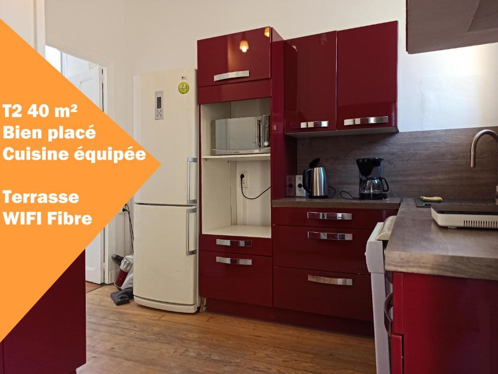 une cuisine avec des armoires rouges et des appareils électroménagers dans l'établissement T2 Toulouse Saint cyprien 40m2 indépendant, quartier sympa, 1er étage sur 2, Terrasse, à Toulouse