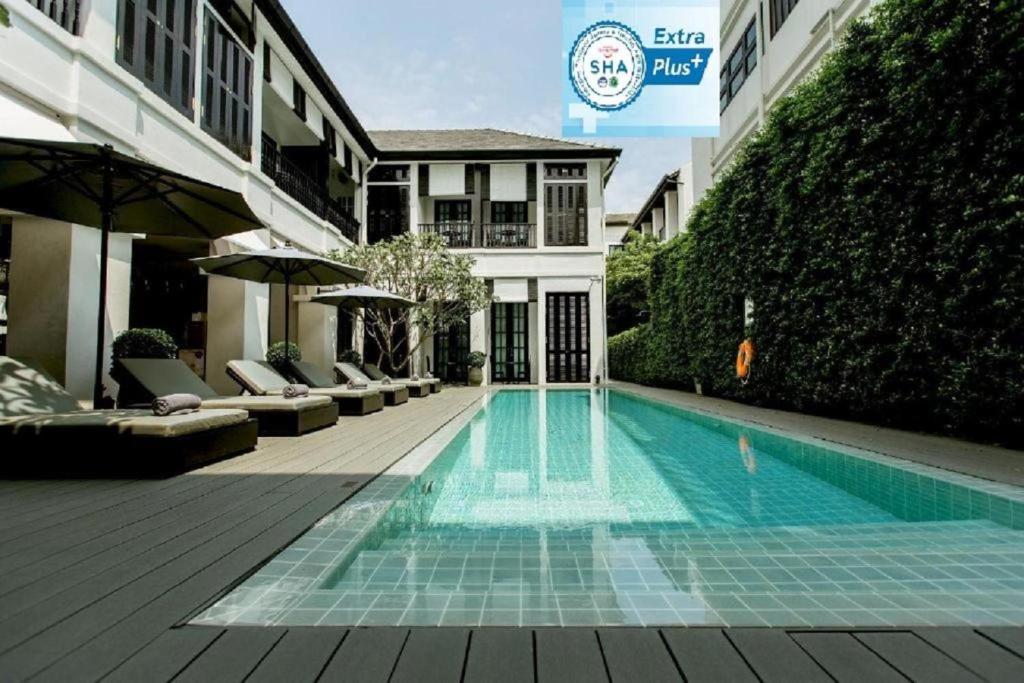 a room with a pool and a blue chair at 99 The Heritage Hotel-SHA Extra Plus Certified in Chiang Mai