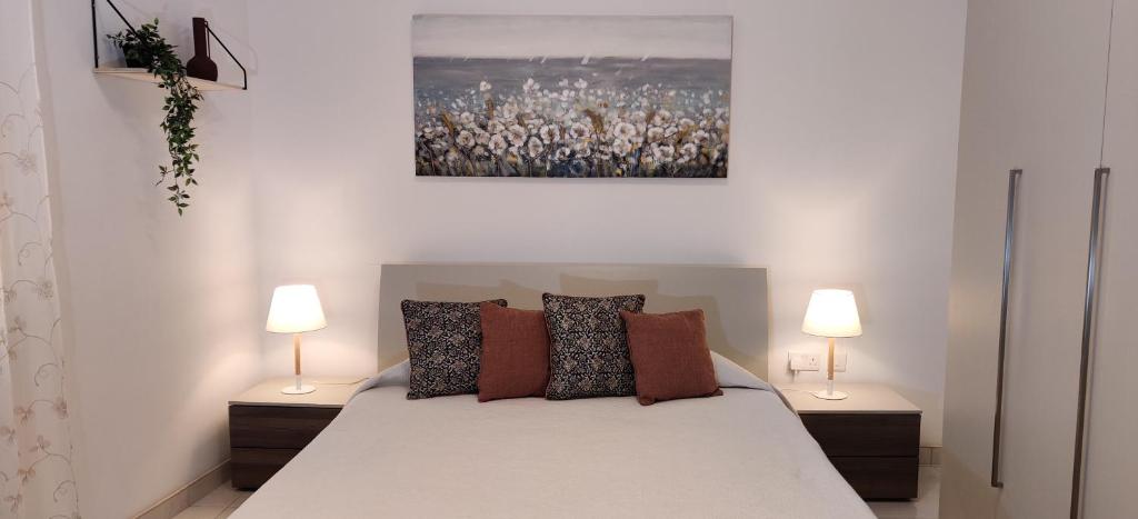 a bedroom with a large bed with two lamps at Lorenza Letting Maisonette in Marsaxlokk