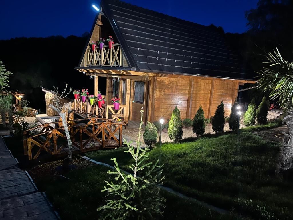 a cabin with people on the balcony at night at Apartmani Joka i Drvene kucice in Vrdnik