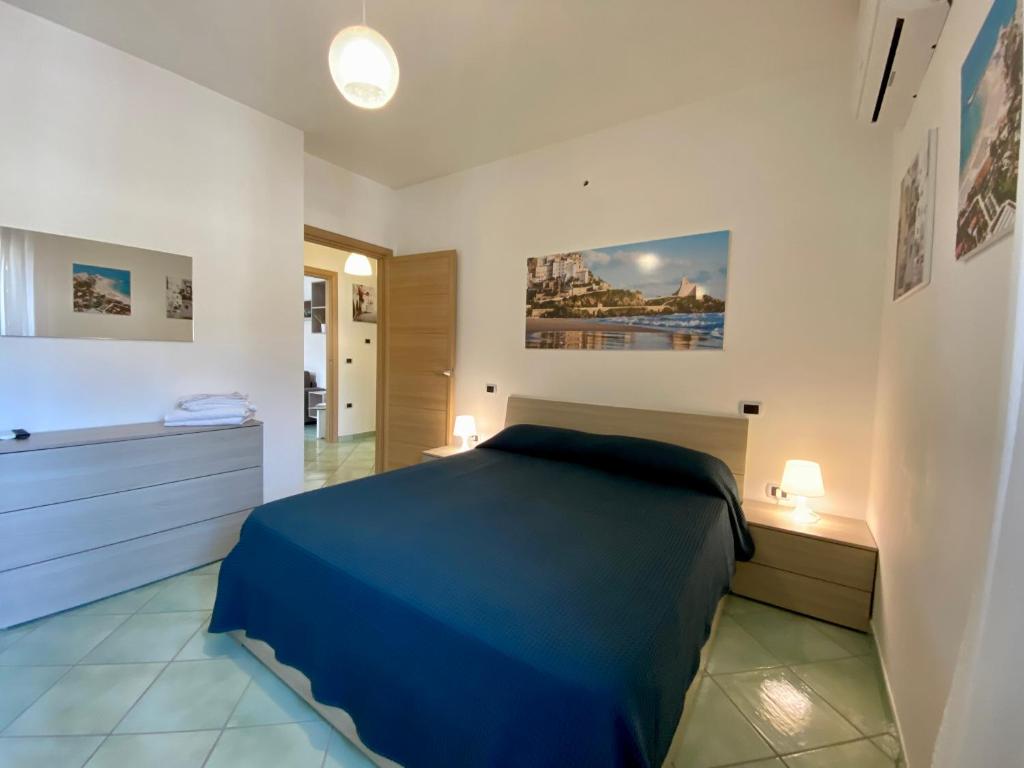 sypialnia z niebieskim łóżkiem i łazienką w obiekcie Ganimede Apartament w mieście Sperlonga