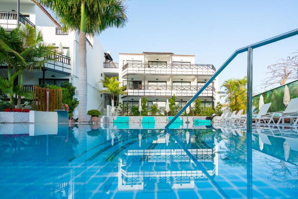 a swimming pool in front of a building at Vanilla Garden Boutique Hotel - Adults Only in Playa de las Americas