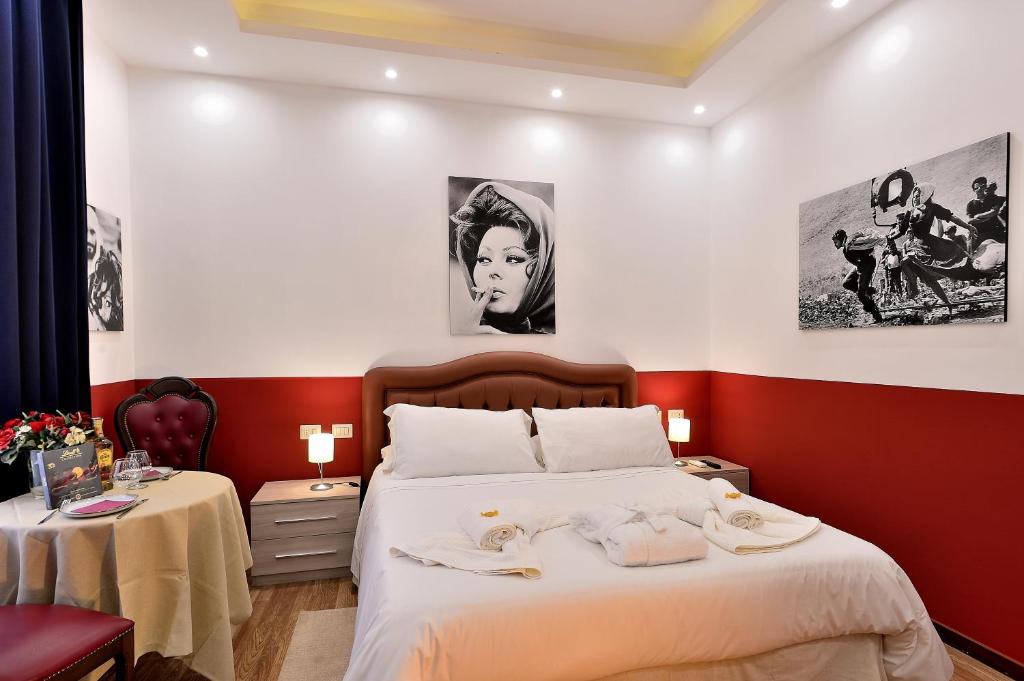a bedroom with a bed with a red accent wall at DolceVeneto Rooms & Suites in Rome