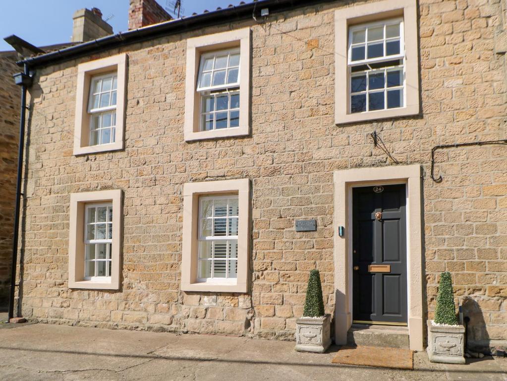 uma casa de tijolos com uma porta preta e janelas em Deanery View em Darlington