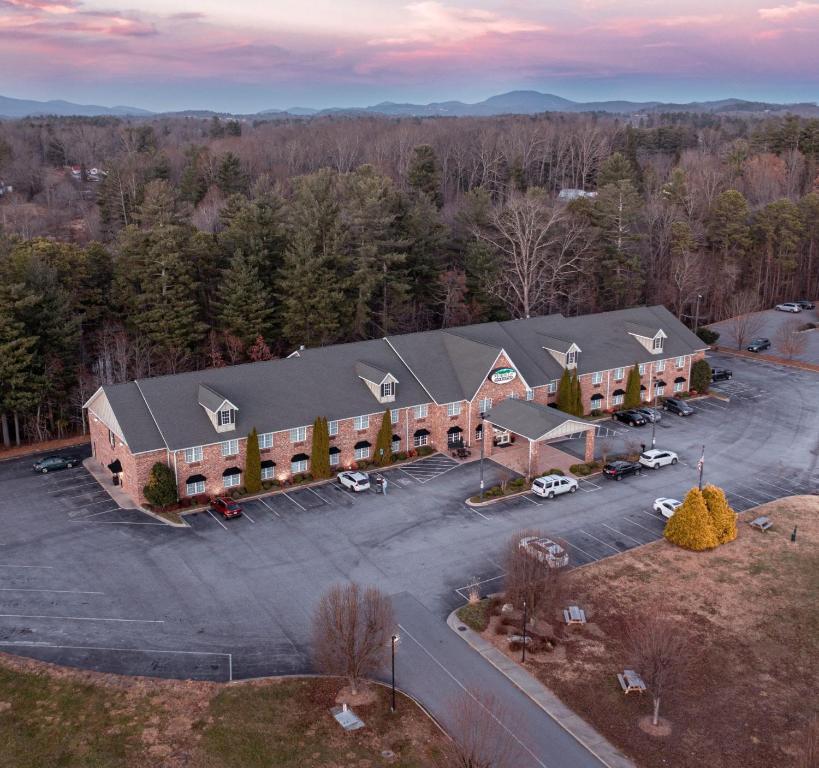 eine Luftansicht eines Gebäudes mit einem Parkplatz in der Unterkunft Mountain Inn & Suites Flat Rock in Flat Rock