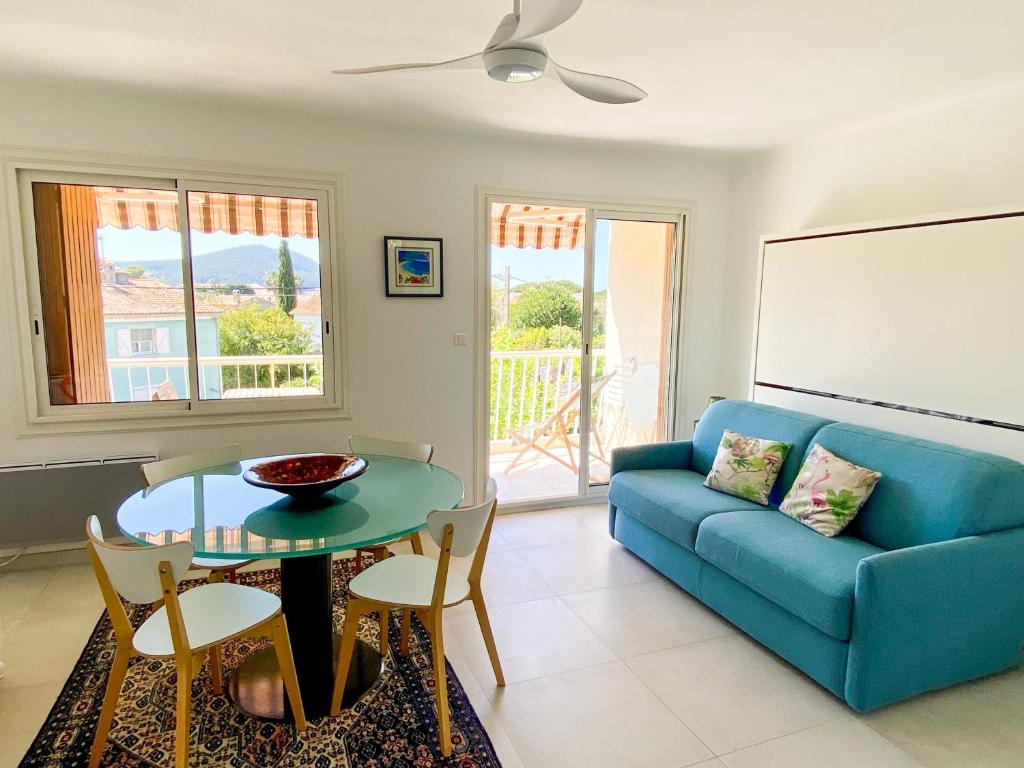 a living room with a blue couch and a table at Appartement la Frégate avec terrasse à 100m de la plage in Saint-Cyr-sur-Mer