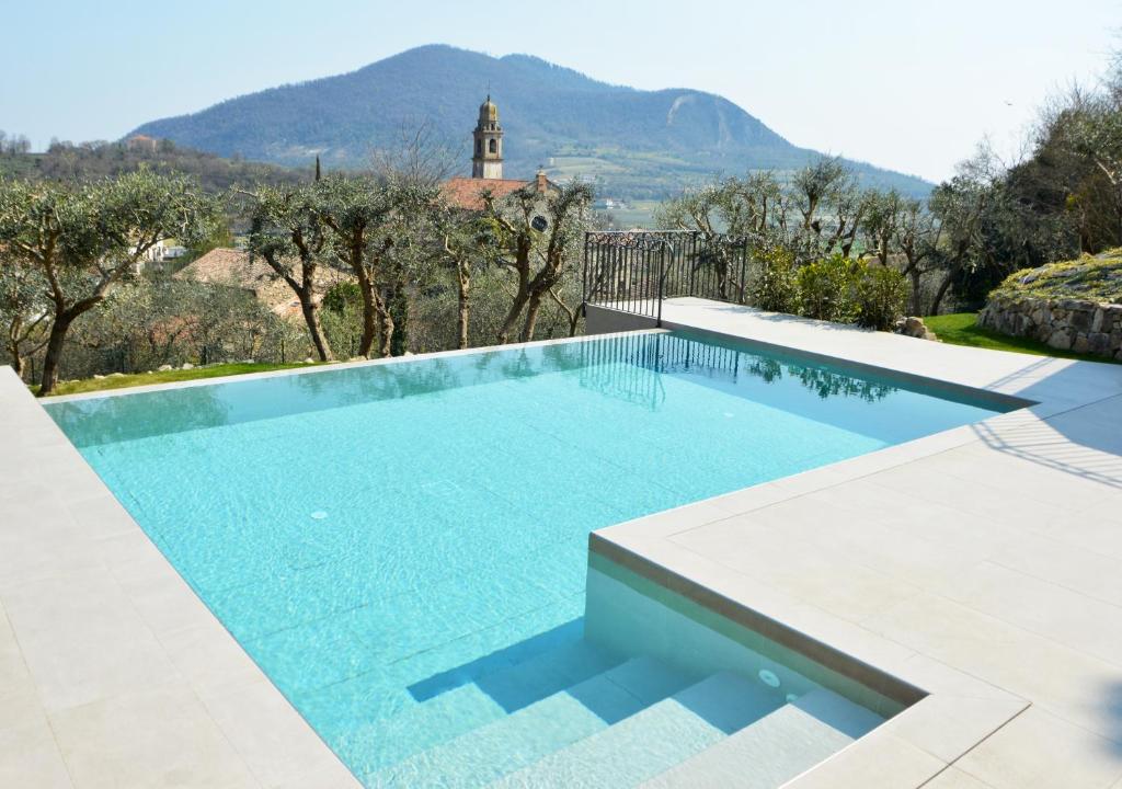 uma piscina numa villa com uma montanha ao fundo em Borgo Petrarca em Arqua Petrarca