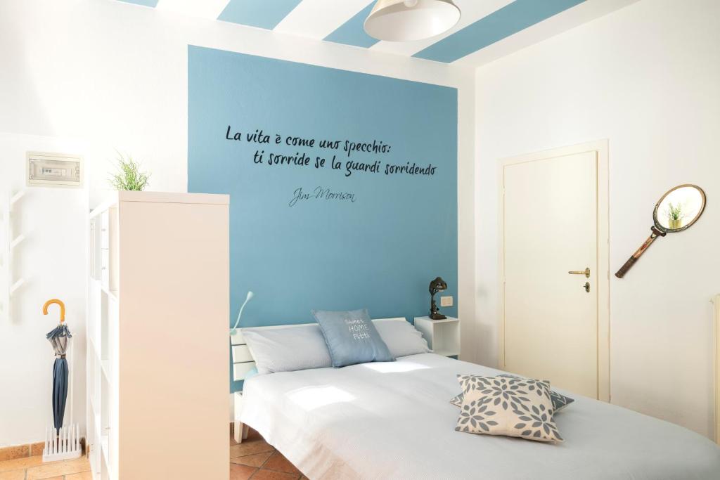 a bedroom with a bed with a blue accent wall at Sweet Home Pitti Verdelli in Crema