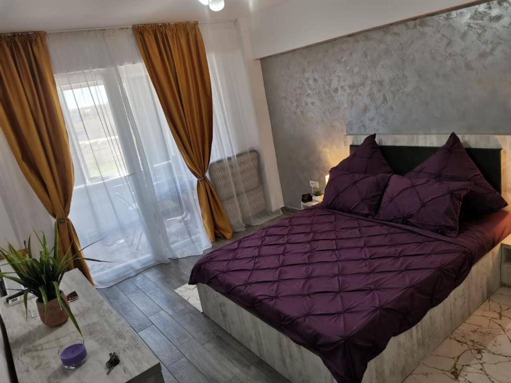 ナボダリにあるGarsonieraのベッドルーム1室(紫色のベッド1台、紫色の掛け布団付)
