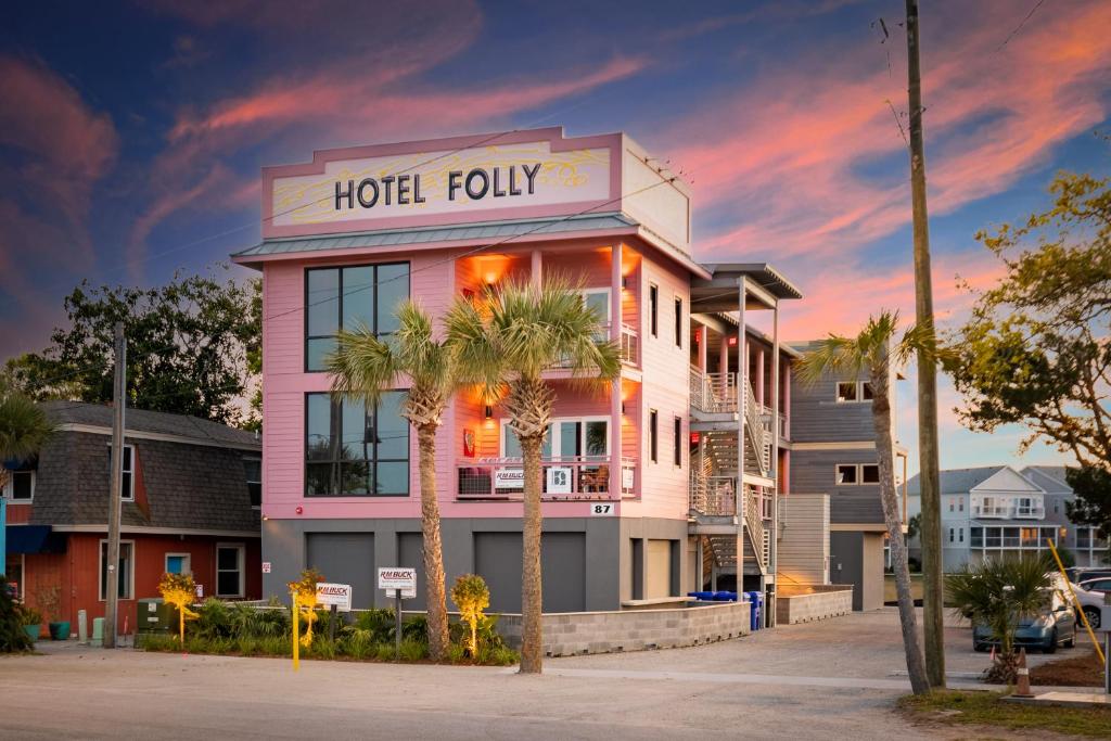 a hotel with palm trees in front of a building at Hotel Folly with Marsh and Sunset Views in Folly Beach