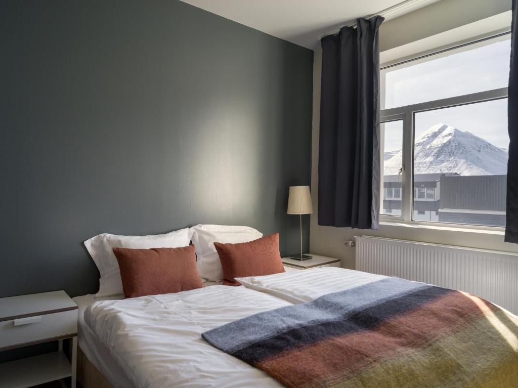a bedroom with a bed with a view of a mountain at Salt Guesthouse in Siglufjörður