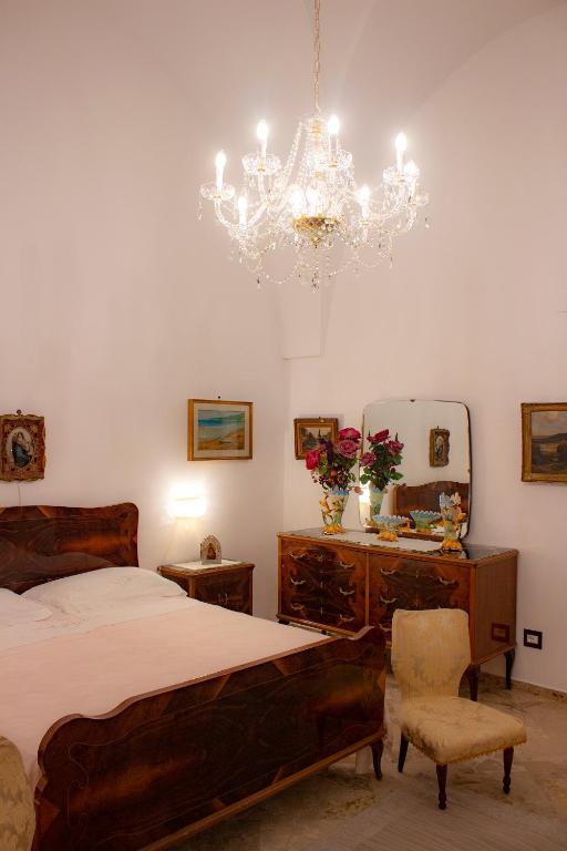 sypialnia z łóżkiem i żyrandolem w obiekcie Amata Casa w mieście Muro Leccese
