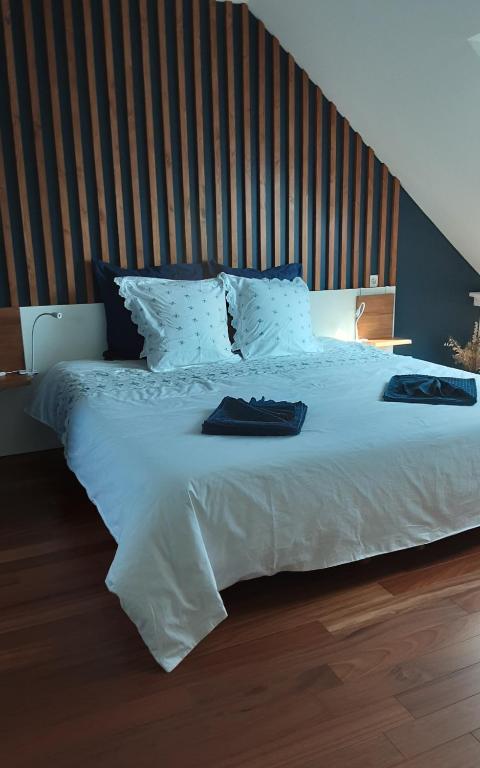 a bedroom with a large white bed with a wooden headboard at Kerlobek Albacore in Groix