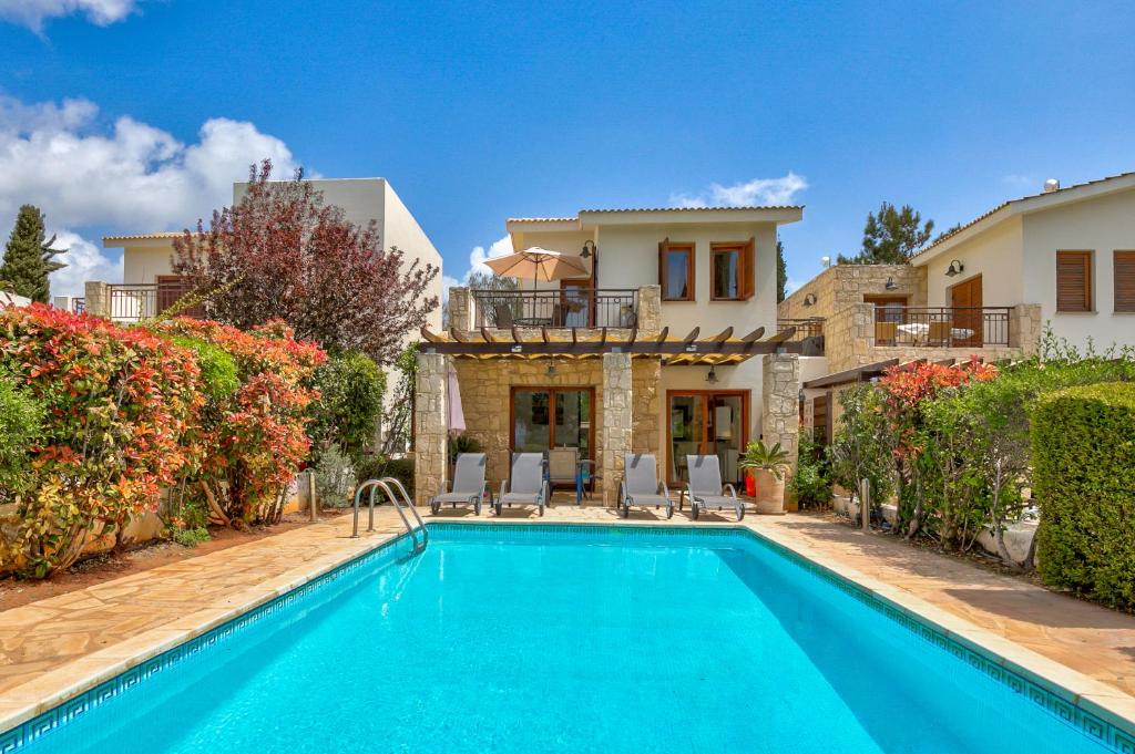 a villa with a swimming pool and a house at 2 bedroom Villa Destu with private pool and golf views, Aphrodite Hills Resort in Kouklia