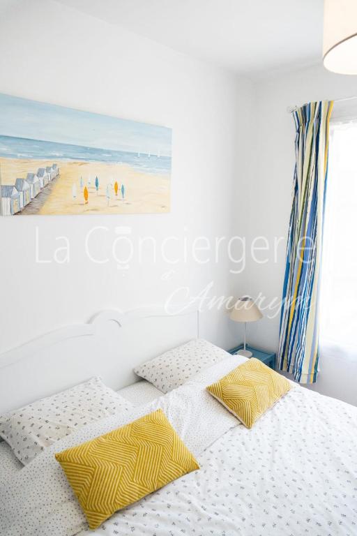 a bedroom with two beds and a painting of a beach at A 2 PAS du PORT in Saint-Valéry-sur-Somme