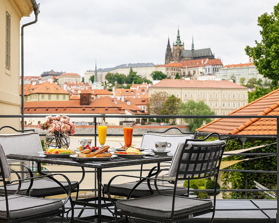 d'une table et de chaises sur un balcon avec vue sur la ville. dans l'établissement Four Seasons Hotel Prague, à Prague