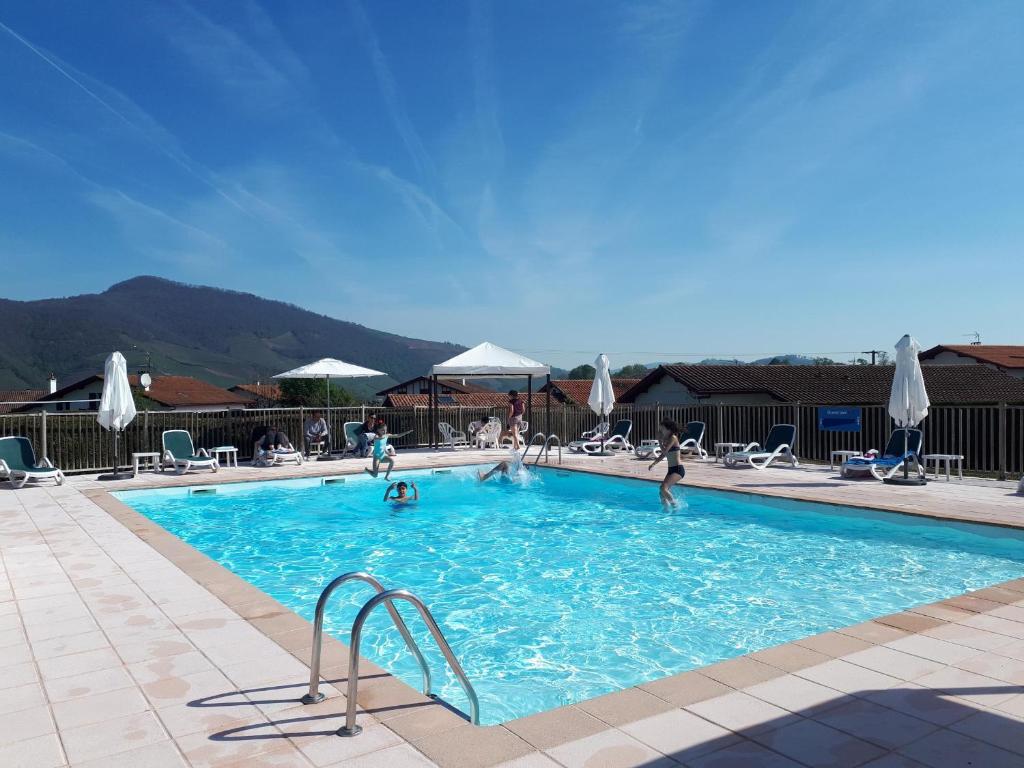 una piscina con gente jugando en el agua en VVF Résidence Pays Basque Saint-Jean-Pied-de-Port, en Saint-Jean-Pied-de-Port