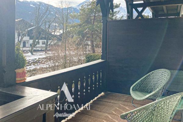 porche con 2 sillas y ventana con vistas en Alpenhoamat Apartments en Garmisch-Partenkirchen