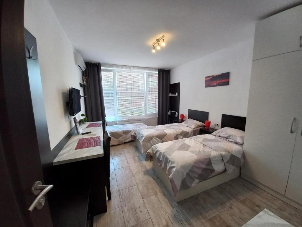 a hotel room with two beds and a television at Sofia Druzba Residence Apart&Conference in Sofia