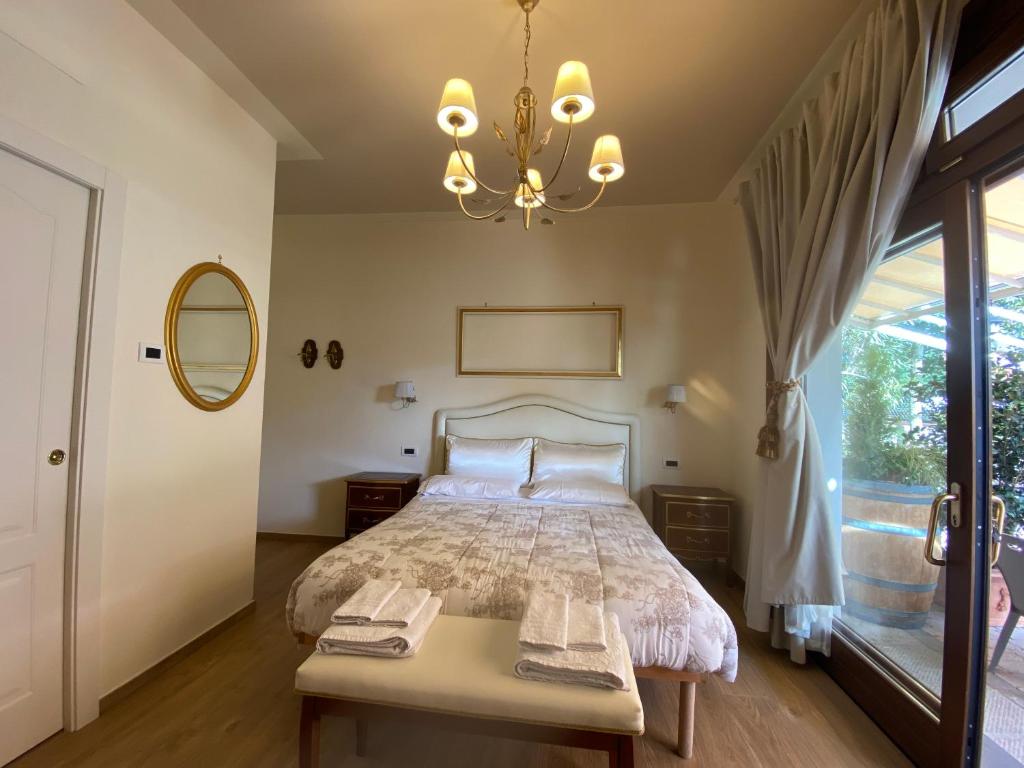 1 dormitorio con 1 cama con mesa y lámpara de araña en B&B Fior Di Toscana, en Serravalle Pistoiese