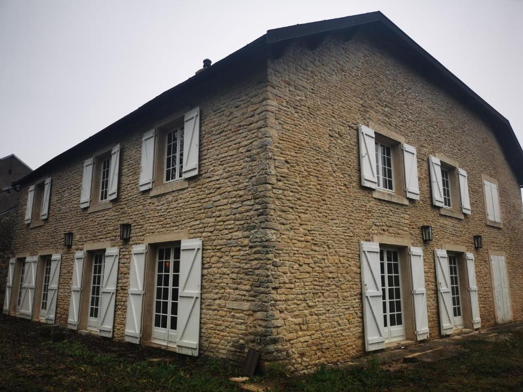 ein altes Backsteingebäude mit weißen Fenstern in der Unterkunft maison de campagne in Isômes